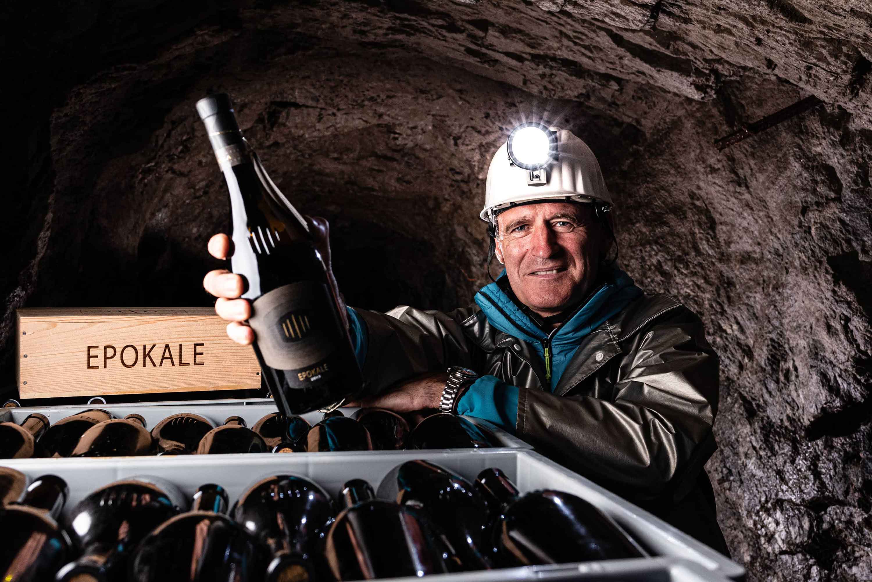 Bild vom Kellermeister Willi Stürz von der Kellerei Cantina Tramin in seinem Bergstollen in Südtirol mit einer Flasche Epokale